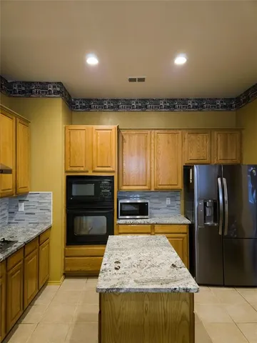 a kitchen with stainless steel appliances granite countertop a sink a stove and refrigerator