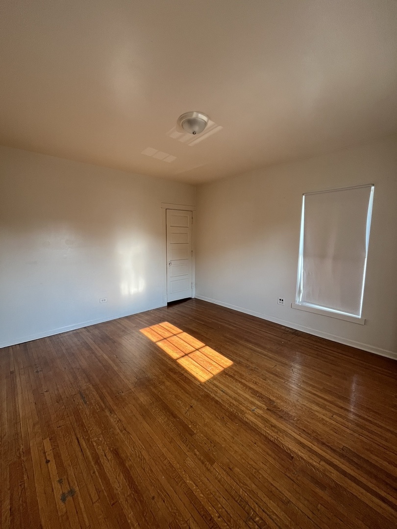 307 Herkimer Street, Unit 2R Joliet, IL 60432 - Photo 13 of 17 an empty room with wooden floor and windows