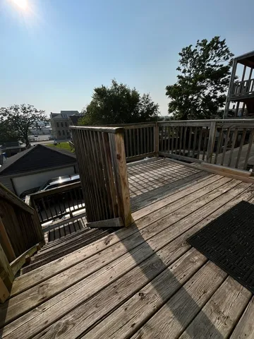 a view of a roof deck with wooden floor and fence