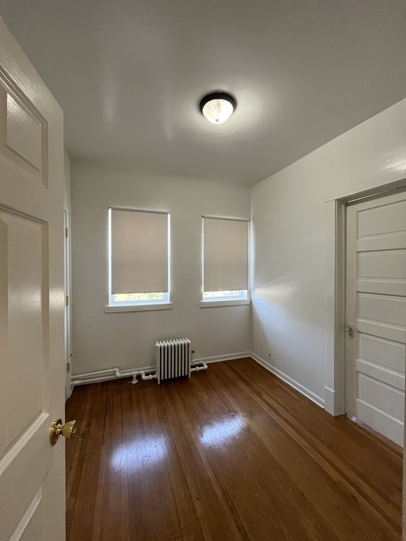 307 Herkimer Street, Unit 2R Joliet, IL 60432 - Photo 5 of 17 an empty room with wooden floor and windows