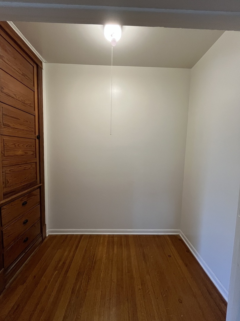 307 Herkimer Street, Unit 2R Joliet, IL 60432 - Photo 6 of 17 a view of an empty room with wooden floor and cabinet