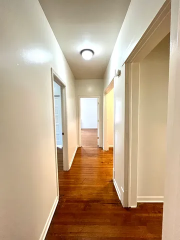 a view of a big room with wooden floor and windows