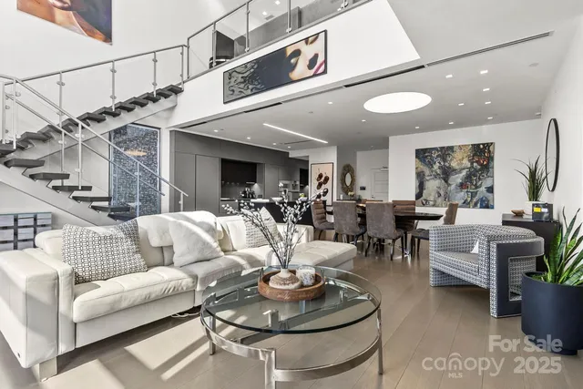 a living room with furniture potted plant and kitchen view