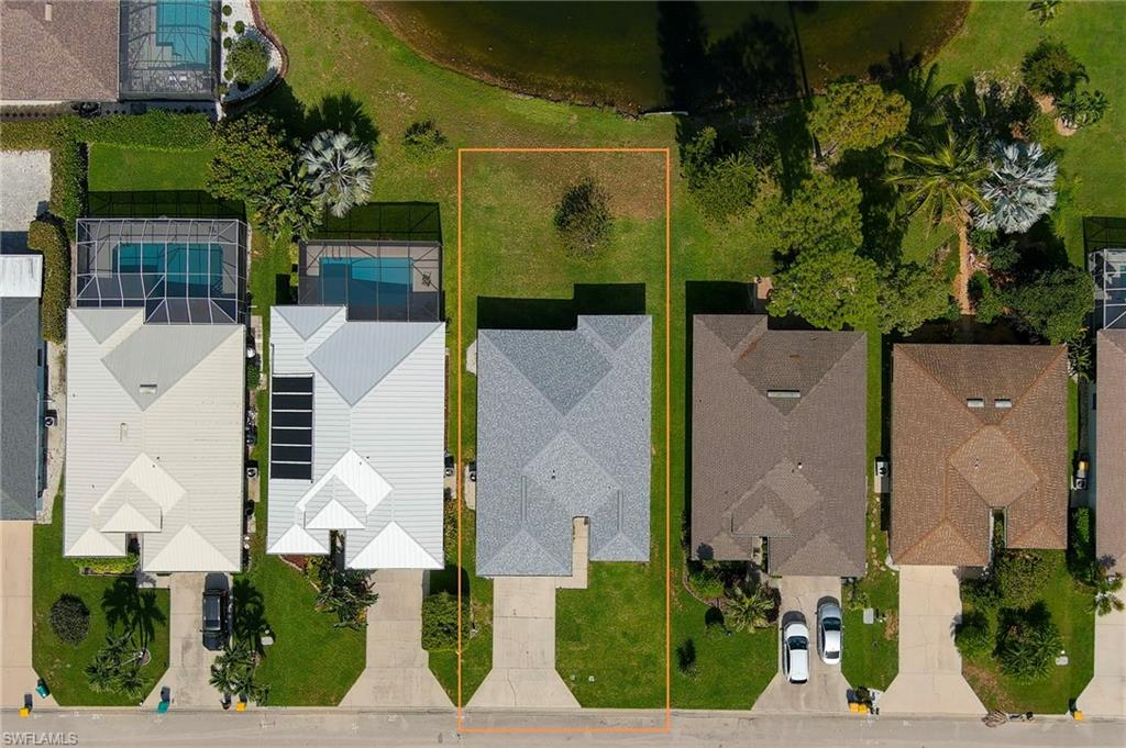 223 Stanhope Circle Naples, FL 34104 - Photo 32 of 41 Aerial perspective showcasing a parcel with a residential structure, green lawn, and a paved driveway