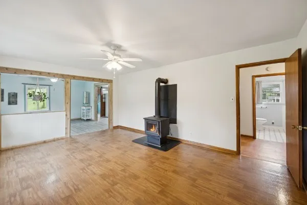 a view of an empty room with window and wooden floor