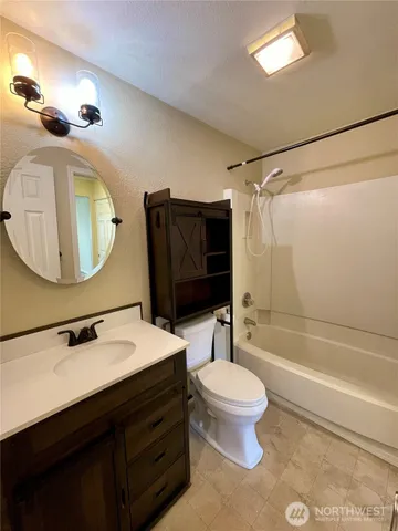 a bathroom with a sink a toilet a mirror and shower