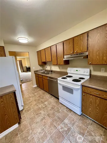 a kitchen with stainless steel appliances granite countertop a stove a sink and a refrigerator