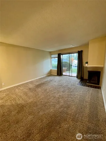 an empty room with a fireplace and large window