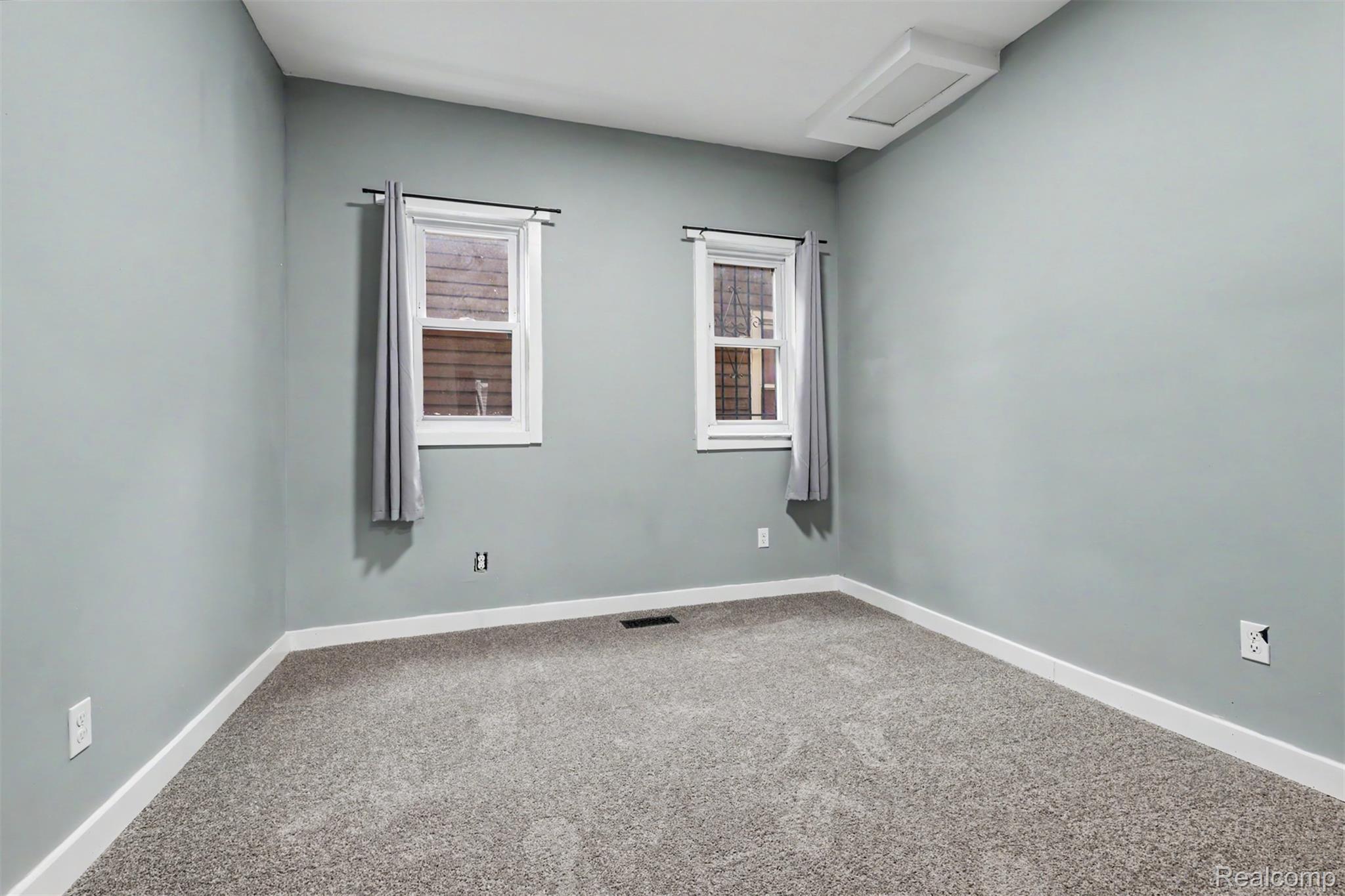8397 Lane Street Detroit, MI 48209 - Photo 19 of 41 Light blue wall paint, neutral carpet flooring, white trim, and two windows with white frames