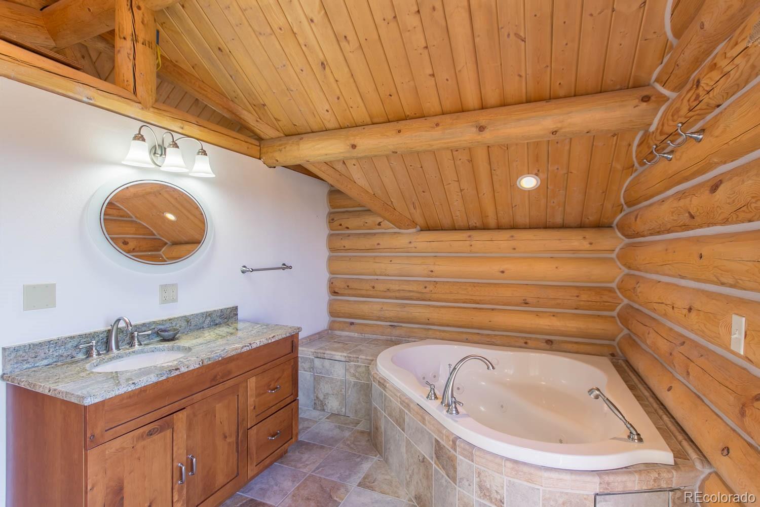 18342 Miller Canyon Ranch Road Glade Park, CO 81523 - Photo 18 of 38 a bathroom with a granite countertop sink and a mirror