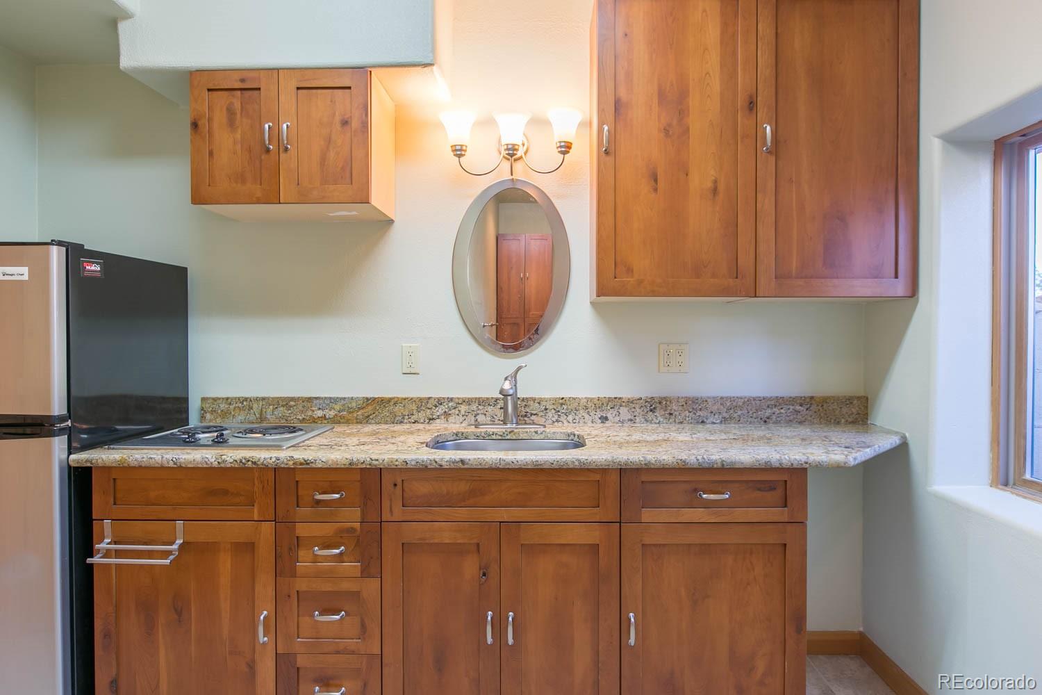 18342 Miller Canyon Ranch Road Glade Park, CO 81523 - Photo 25 of 38 a bathroom with a granite countertop sink a mirror and vanity