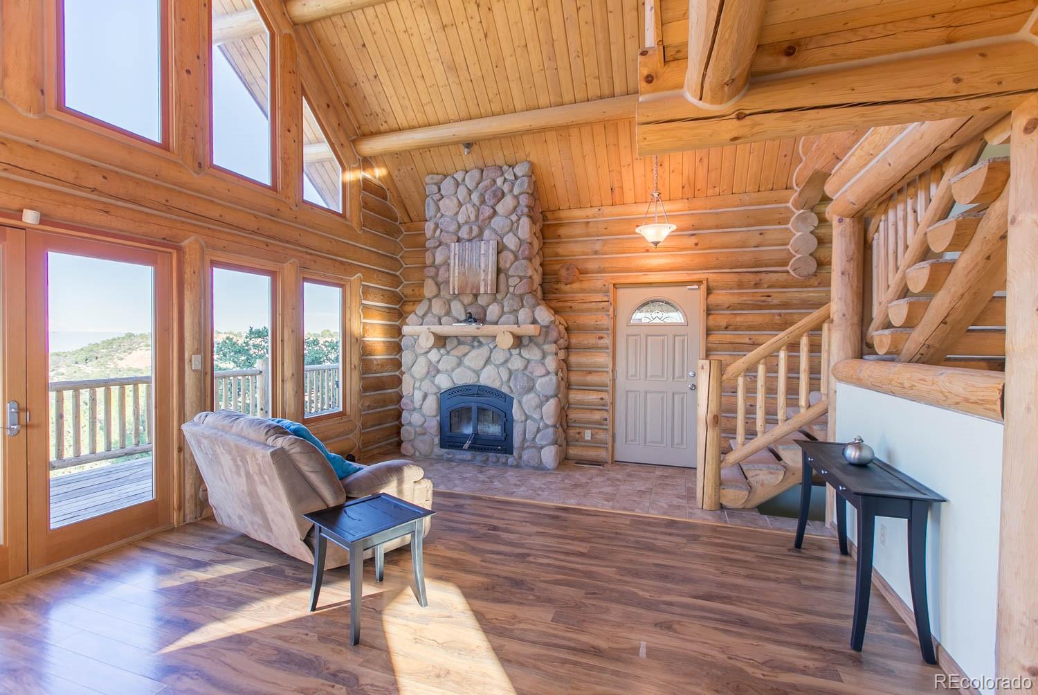 18342 Miller Canyon Ranch Road Glade Park, CO 81523 - Photo 9 of 38 a living room with furniture a fireplace and wooden floor