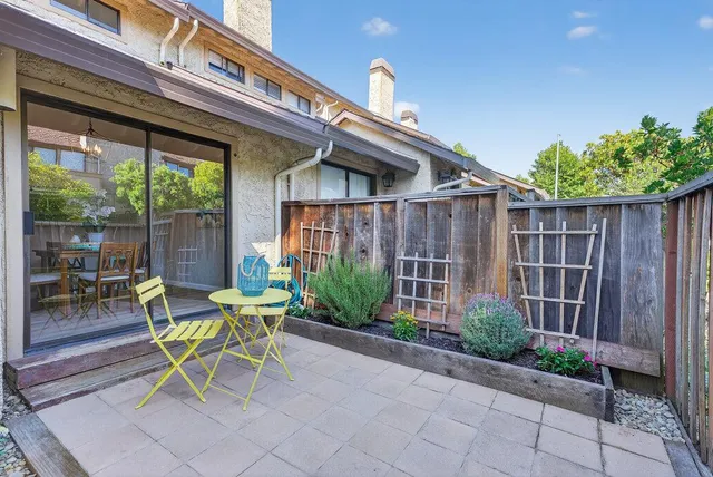 a view of a chair and table in backyard of the house