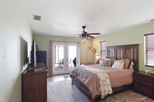 a bedroom with a bed flat screen tv and window