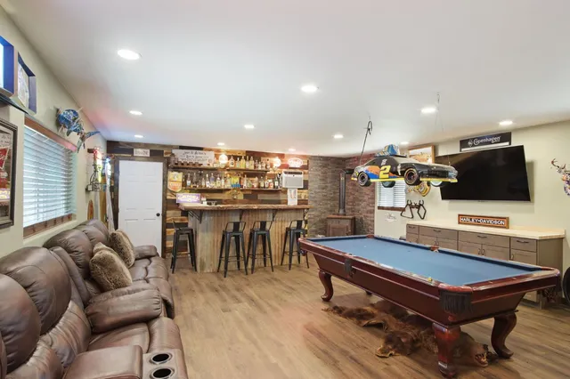 a living room with furniture pool table and a flat screen tv