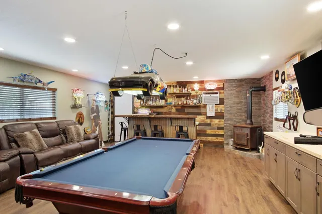 a living room with stainless steel appliances furniture a rug and a kitchen view