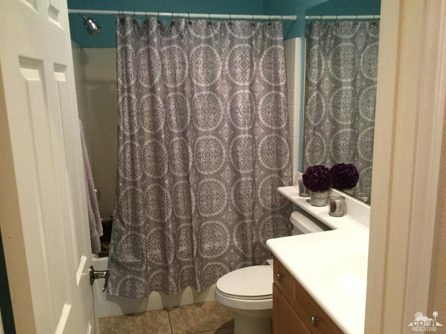 83316 Lone Star Road Indio, CA 92203 - Photo 17 of 43 a bathroom with a toilet and a shower curtain
