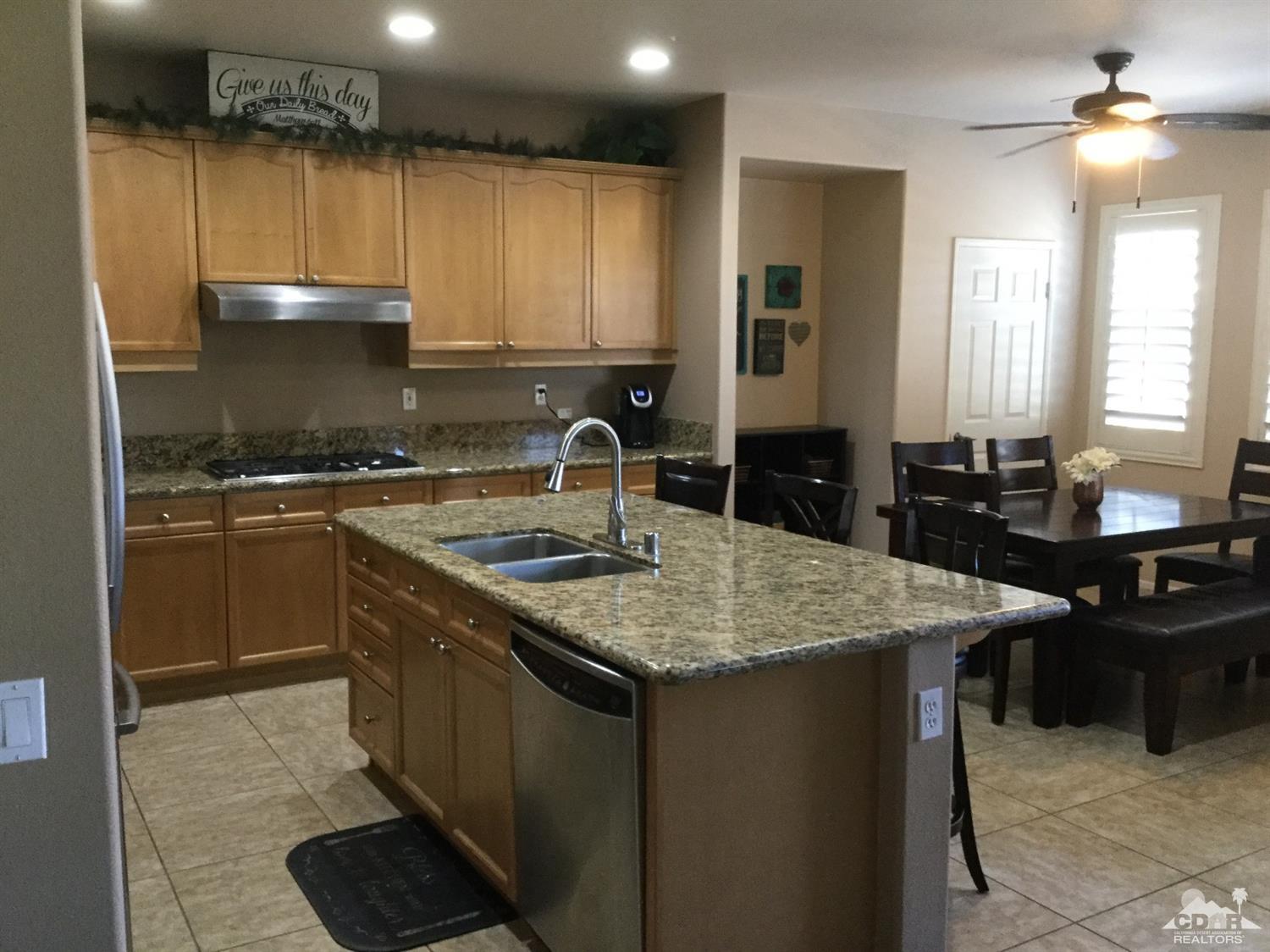 83316 Lone Star Road Indio, CA 92203 - Photo 6 of 43 a kitchen with a sink a stove a refrigerator a dining table and chairs