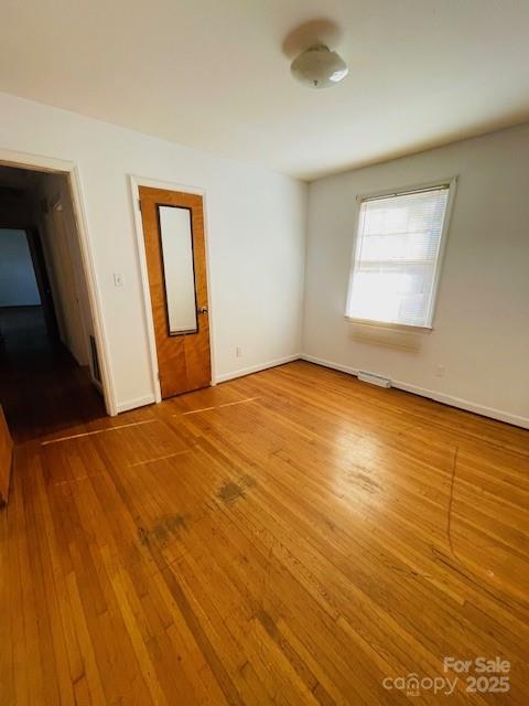 1421 Tyvola Road Charlotte, NC 28210 - Photo 18 of 23 a view of an empty room with wooden floor and a window