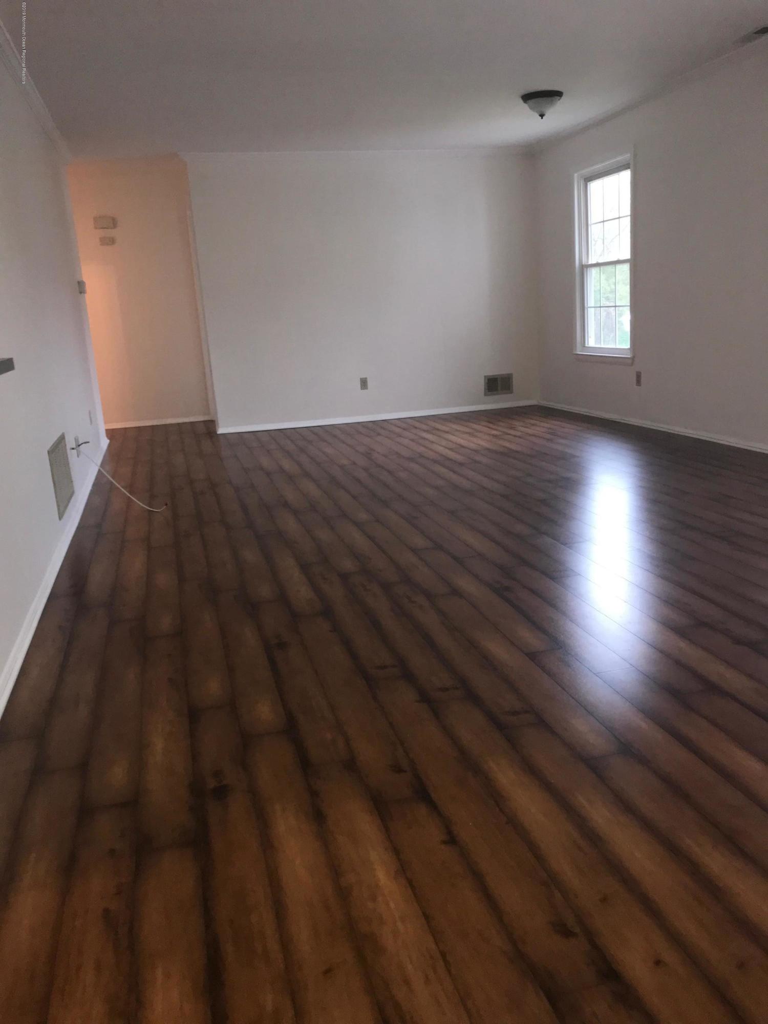 509 Harding Road, Unit 6 Freehold, NJ 07728 - Photo 3 of 15 an empty room with wooden floor and windows