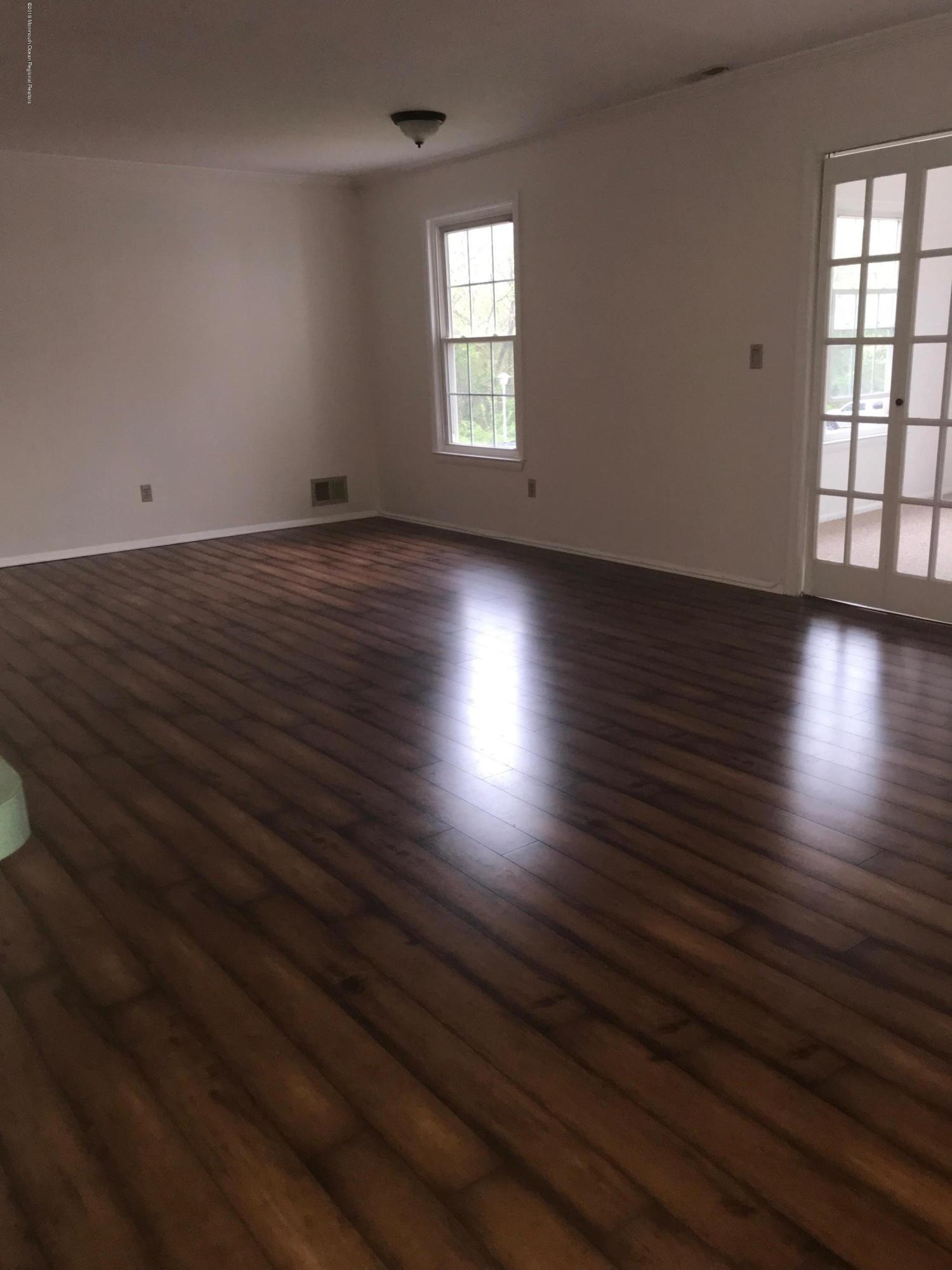 509 Harding Road, Unit 6 Freehold, NJ 07728 - Photo 4 of 15 an empty room with wooden floor and windows