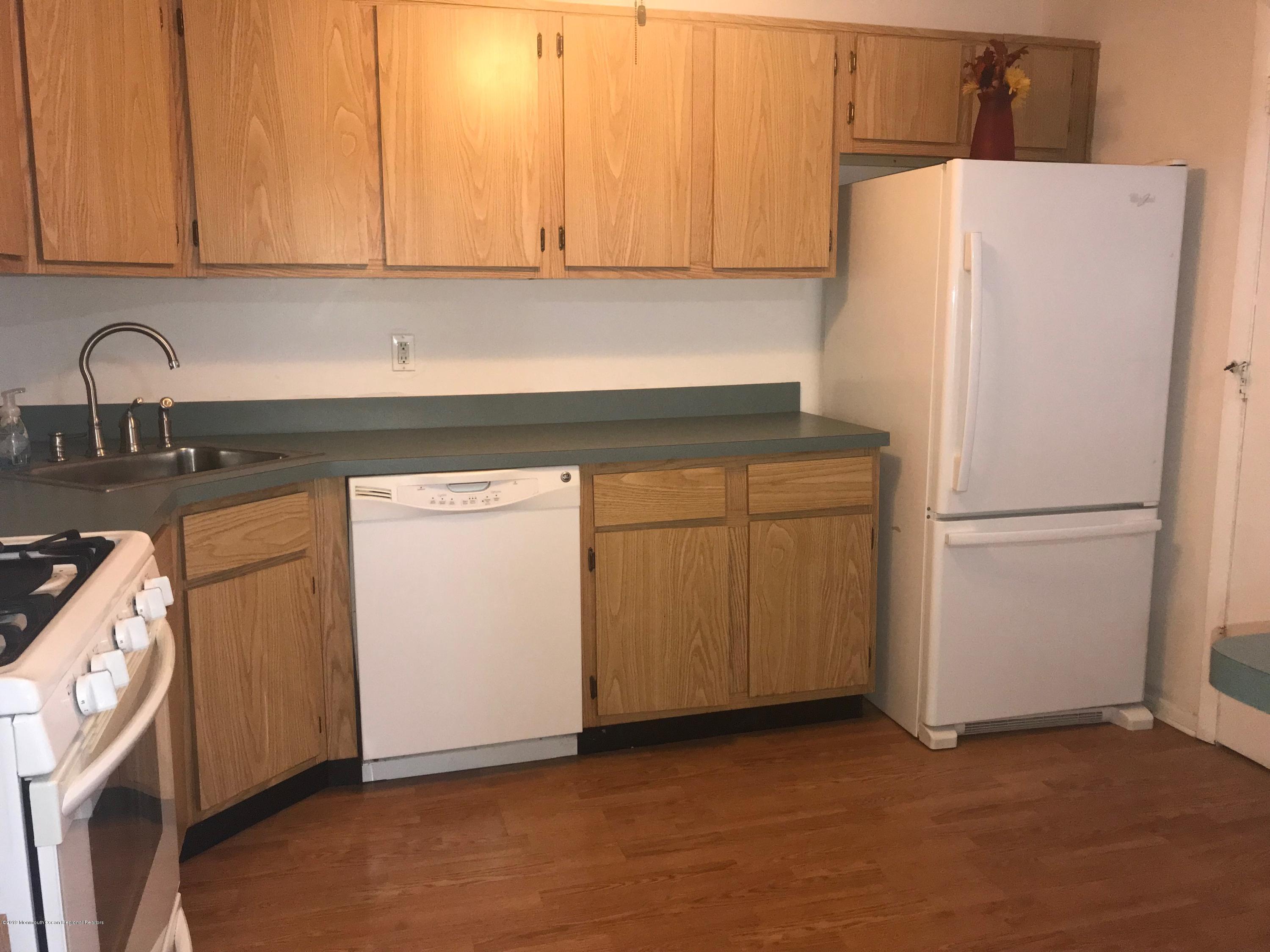 509 Harding Road, Unit 6 Freehold, NJ 07728 - Photo 5 of 15 a kitchen with a refrigerator sink and cabinets