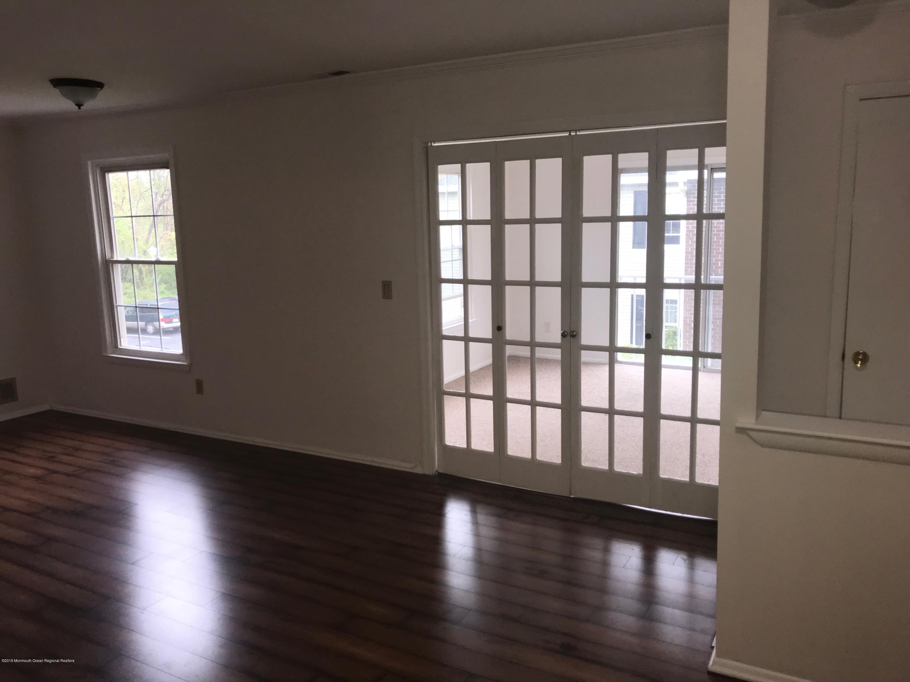 509 Harding Road, Unit 6 Freehold, NJ 07728 - Photo 7 of 15 a view of an empty room with wooden floor and a window