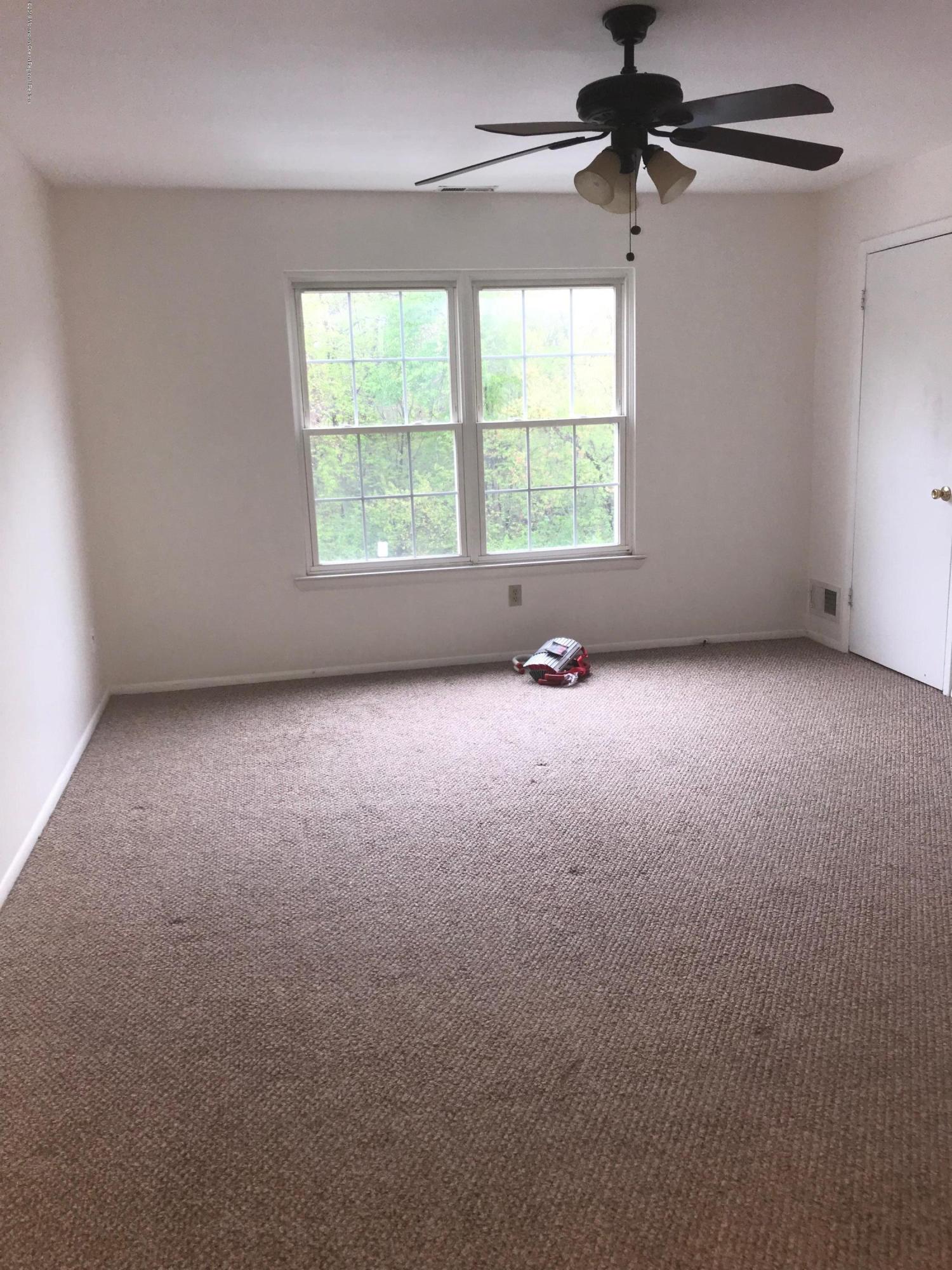 509 Harding Road, Unit 6 Freehold, NJ 07728 - Photo 9 of 15 an empty room with windows and fan
