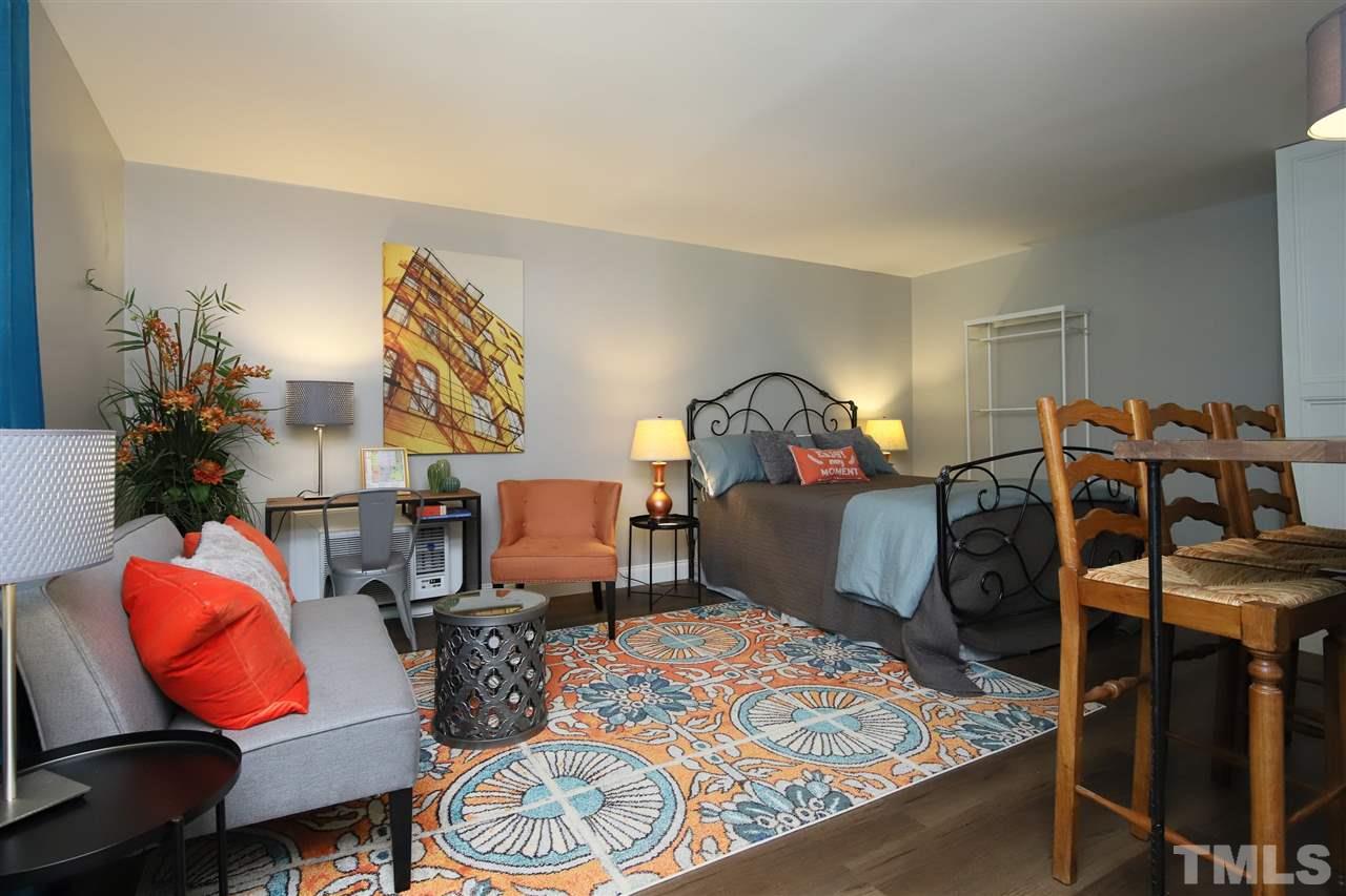 815 Clay Street Raleigh, NC 27605 - Photo 26 of 30 a living room with furniture a rug and a lamp