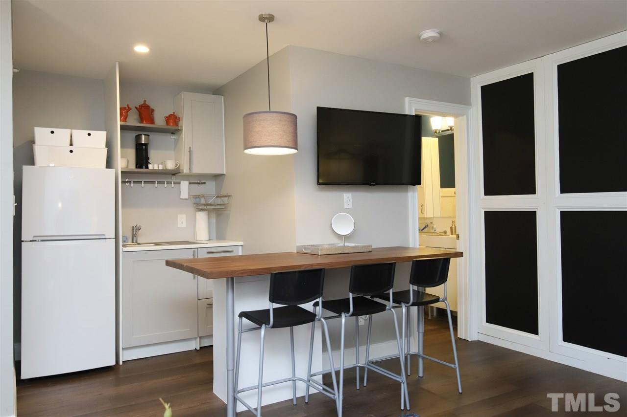 815 Clay Street Raleigh, NC 27605 - Photo 9 of 30 a kitchen with stainless steel appliances a table chairs refrigerator and microwave