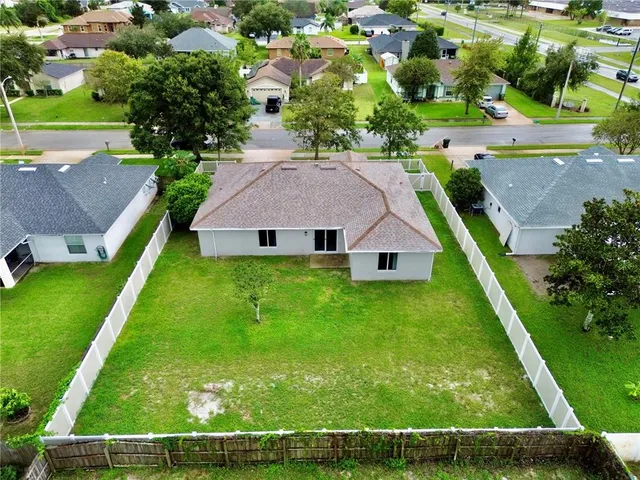 an aerial view of residential houses with yard