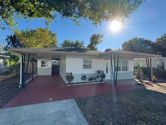 a front view of a house with a yard and potted plants
