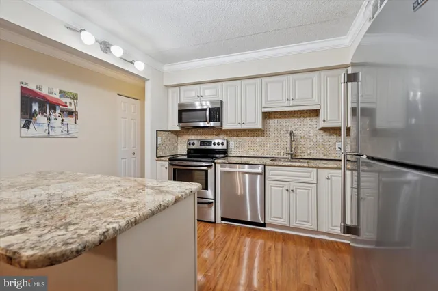 a kitchen with stainless steel appliances granite countertop a refrigerator sink and stove