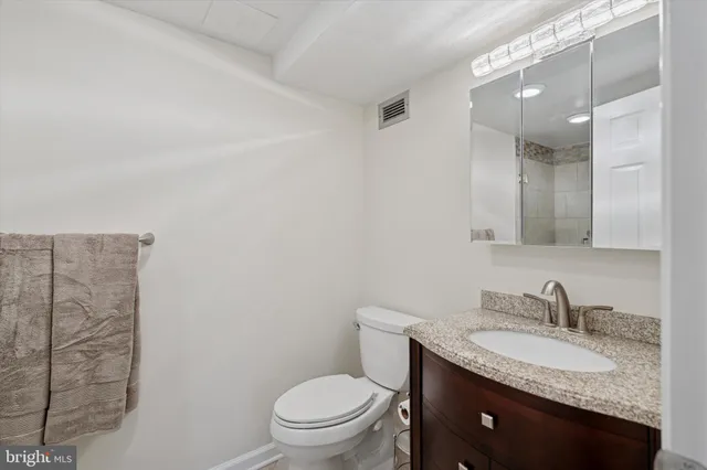 a bathroom with a granite countertop sink toilet and shower