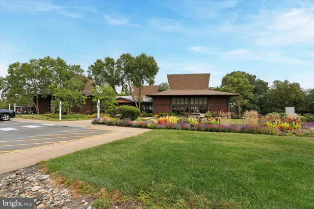 a view of a big house with a big yard and large trees