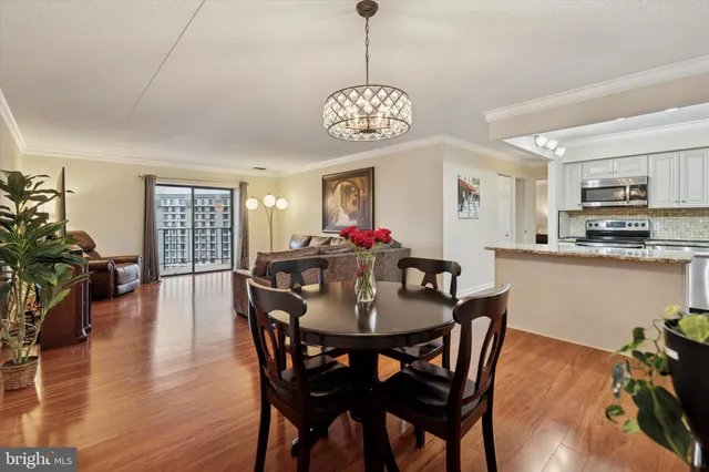 a view of a dining room with furniture wooden floor and a chandelier