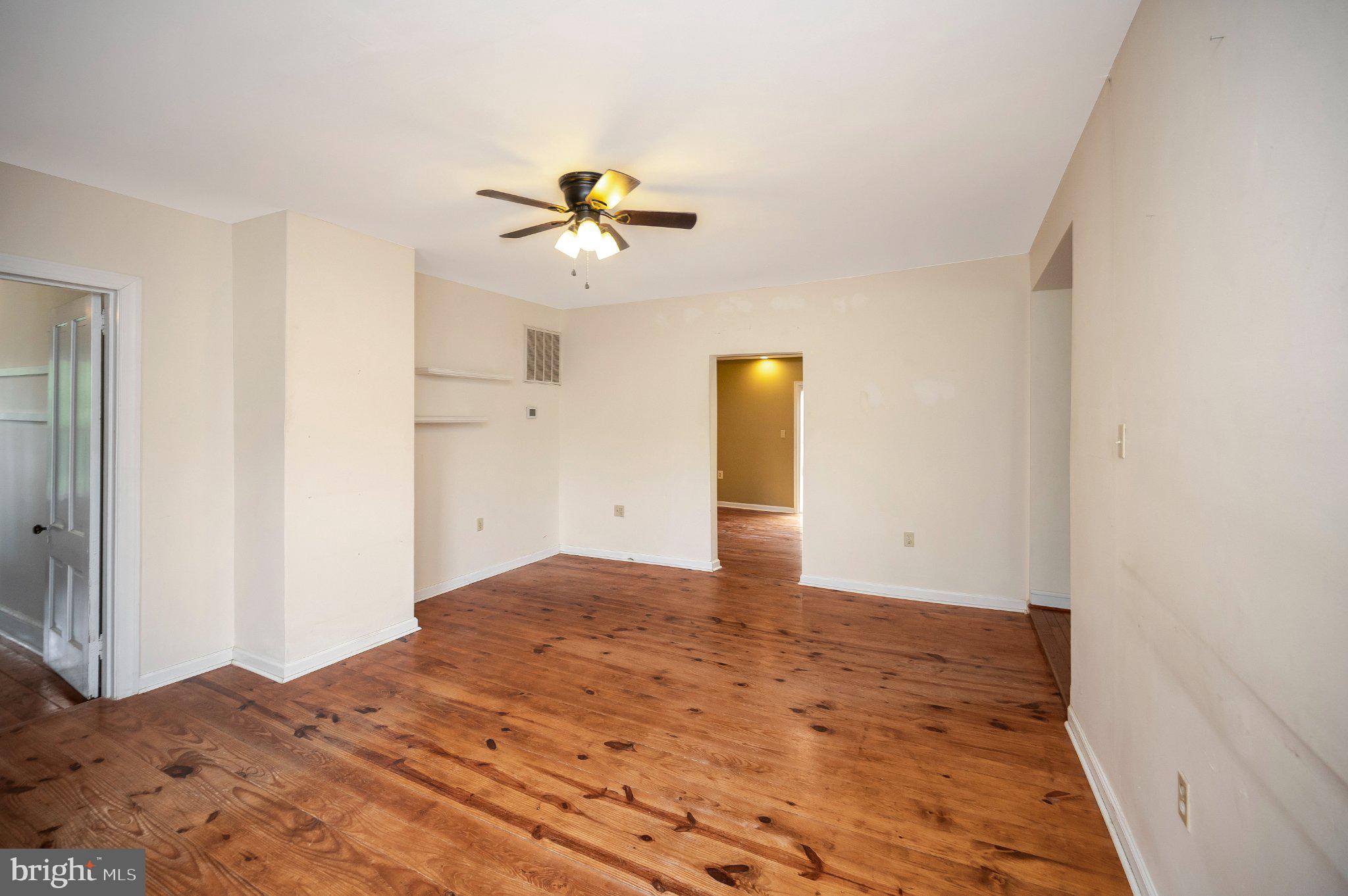23202 Village Road Unionville, VA 22567 - Photo 17 of 58 a view of a big room with wooden floor and a ceiling fan