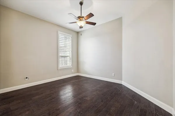 an empty room with windows and fan chandelier fan