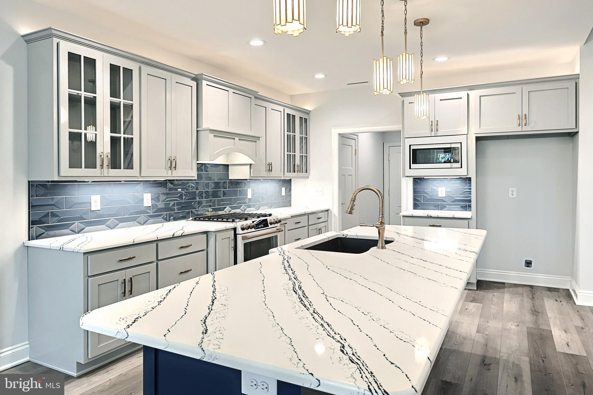 567 Lumber Street Littlestown, PA 17340 - Photo 26 of 62 a kitchen with stainless steel appliances kitchen island granite countertop a stove a sink and white cabinets