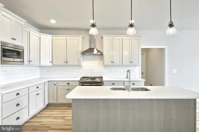a kitchen with kitchen island granite countertop a sink cabinets and stainless steel appliances