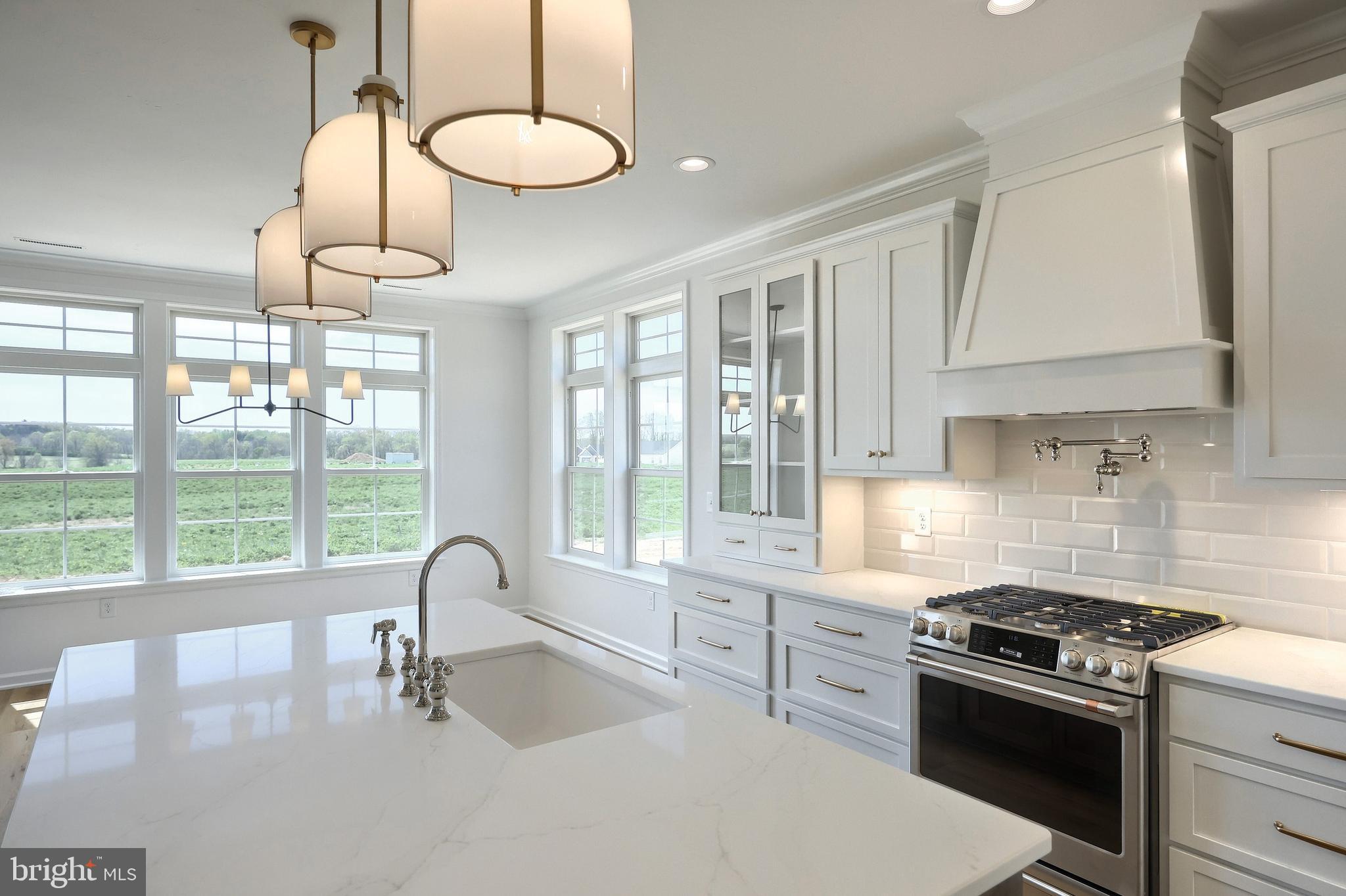 567 Lumber Street Littlestown, PA 17340 - Photo 46 of 62 a kitchen with kitchen island a stove a sink and white cabinets with wooden floor
