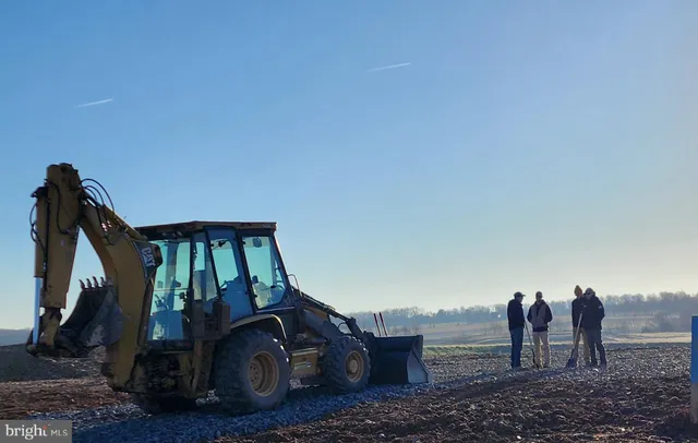 a view of a dry yard with wooden fence