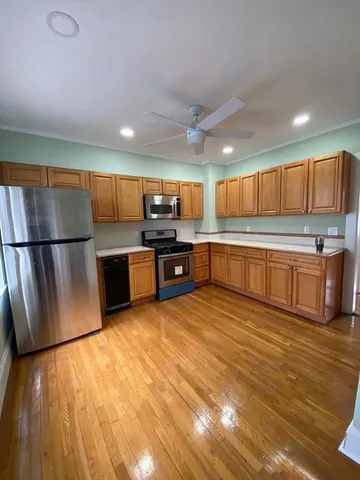 a kitchen with stainless steel appliances granite countertop a refrigerator and a stove top oven