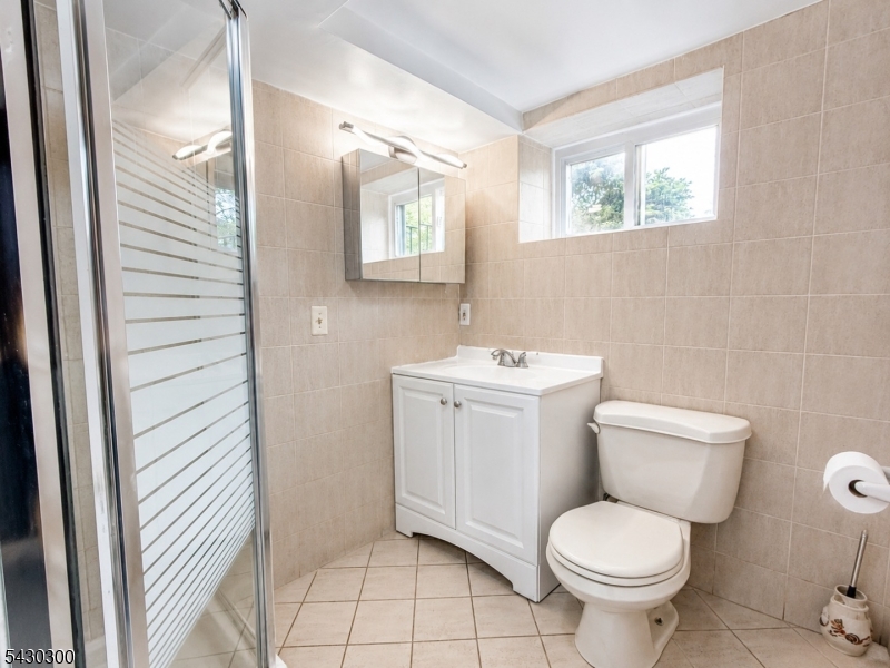 25 Spring Street, Unit A Millburn, NJ 07041 - Photo 17 of 21 a bathroom with a toilet sink and mirror