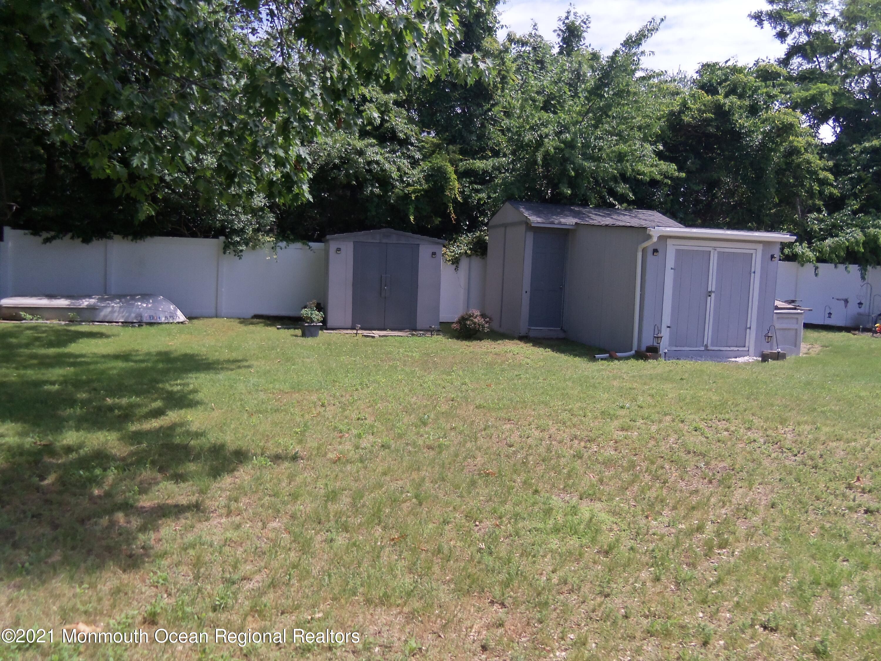 338 Pitcairn Road Brick, NJ 08723 - Photo 24 of 24 a view of a backyard with large trees and wooden fence