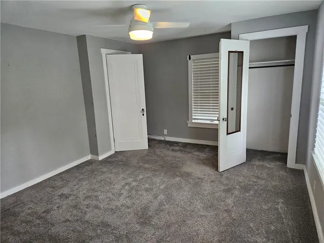 an empty room with windows and closet