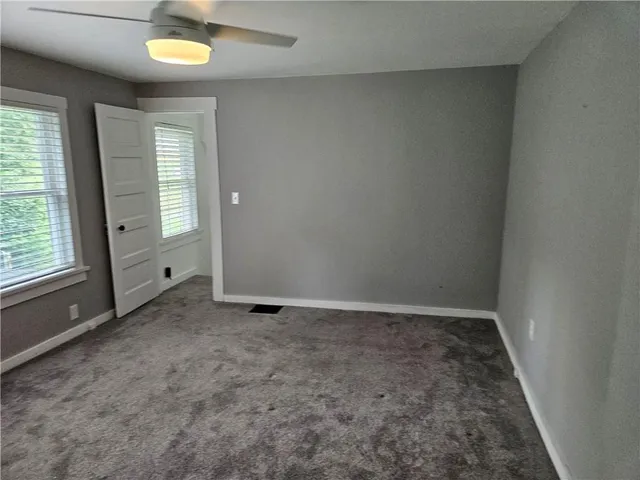 an empty room with closet and windows