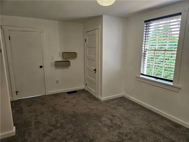 an empty room with closet and windows