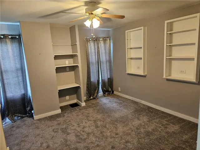 an empty room with windows and cabinet