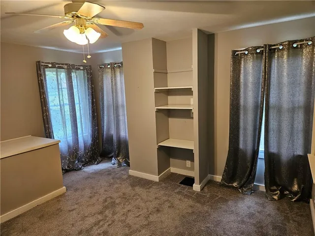 a view of an empty room with window and cabinet